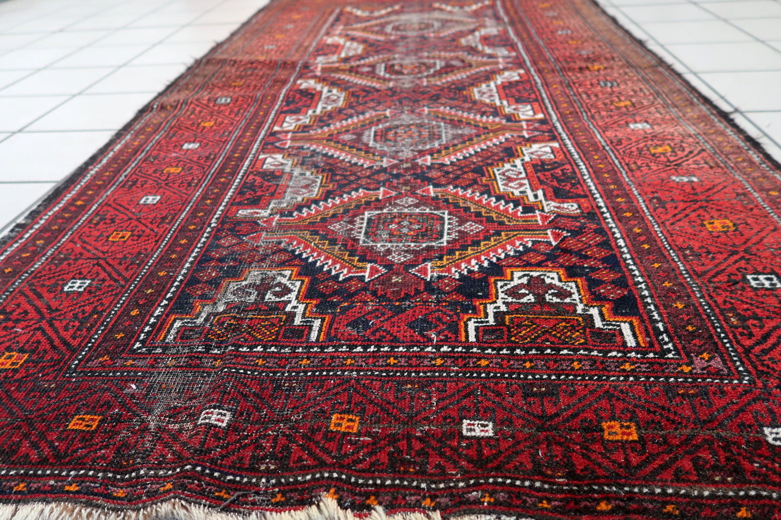 Antique runner with serrated-edge medallions and multiple guard borders in burgundy and gold.

