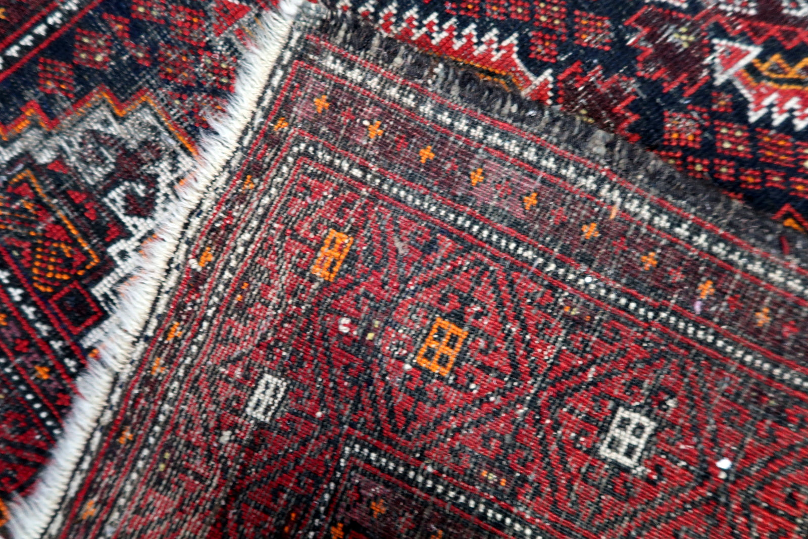 Bold geometric tribal carpet with four large diamonds and traditional Baluch tribal symbols.

