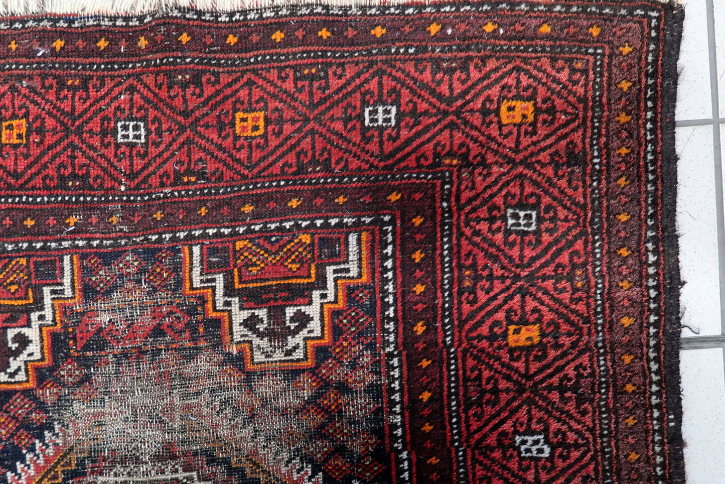 Hand-knotted wool tribal runner with bold geometric patterns in burgundy, crimson, charcoal, and cream.

