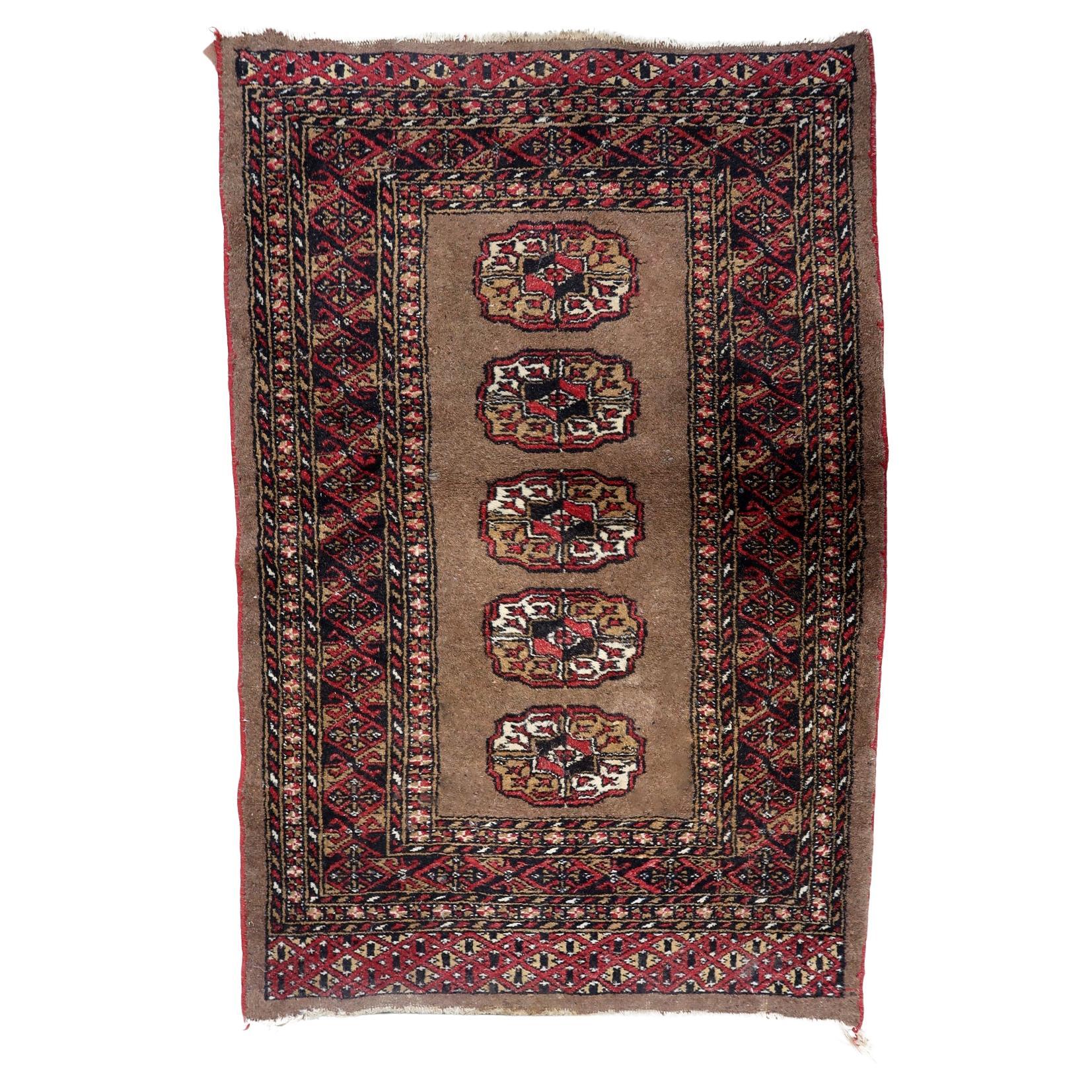Antique Uzbek Bukhara rug from the 1920s featuring five octagonal crimson guls on a warm taupe field.

