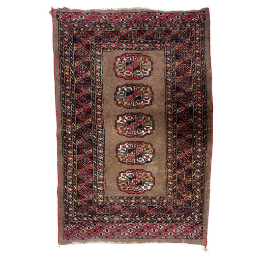 Antique Uzbek Bukhara rug from the 1920s featuring five octagonal crimson guls on a warm taupe field.

