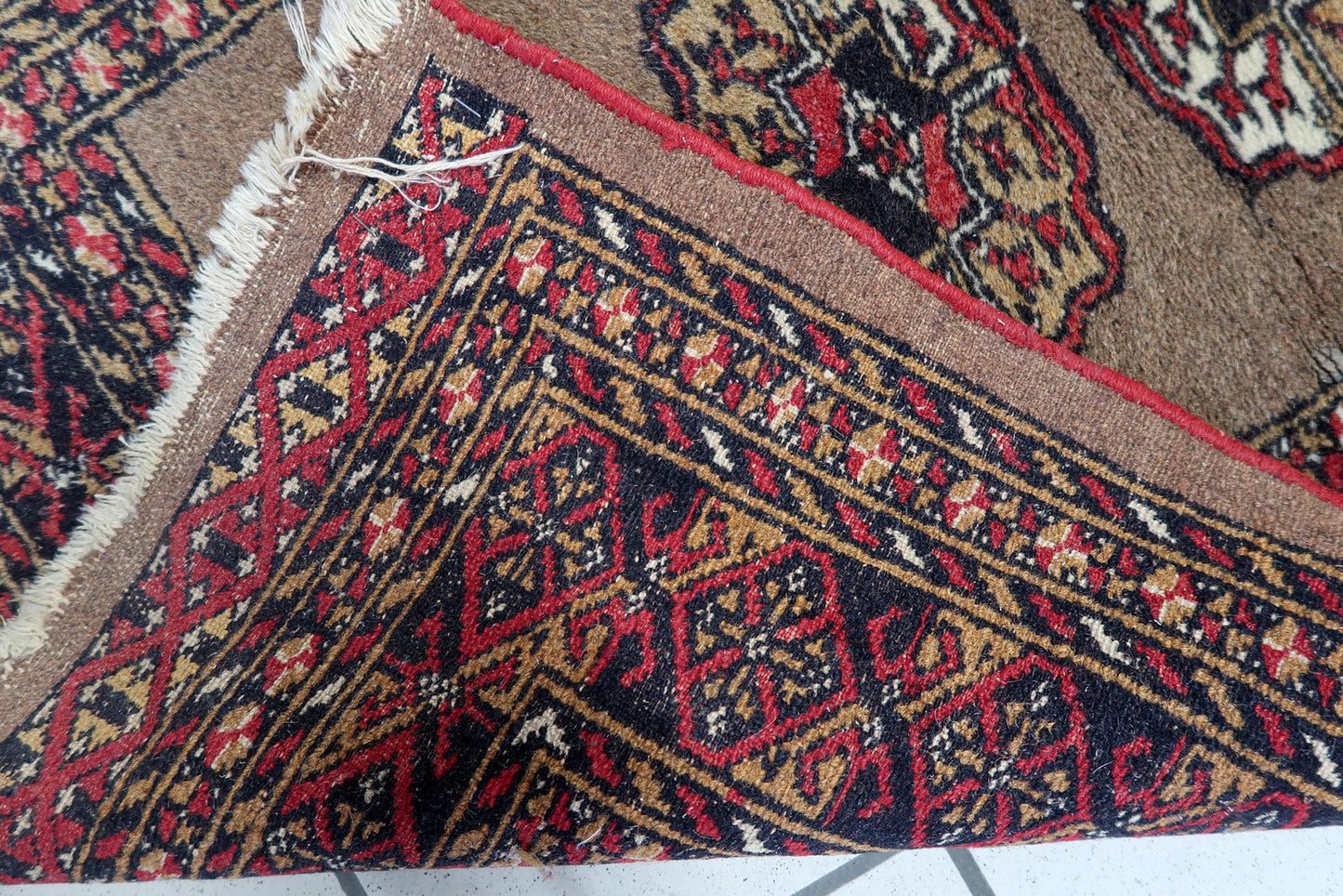 Hand-woven nomadic rug featuring classic Bukhara design elements and stylized floral motifs.

