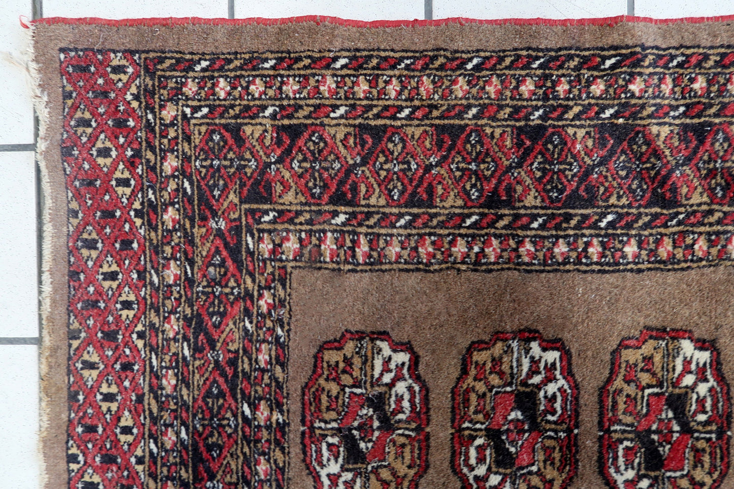 Hand-knotted wool tribal rug with perfectly aligned geometric medallions and intricate borders.

