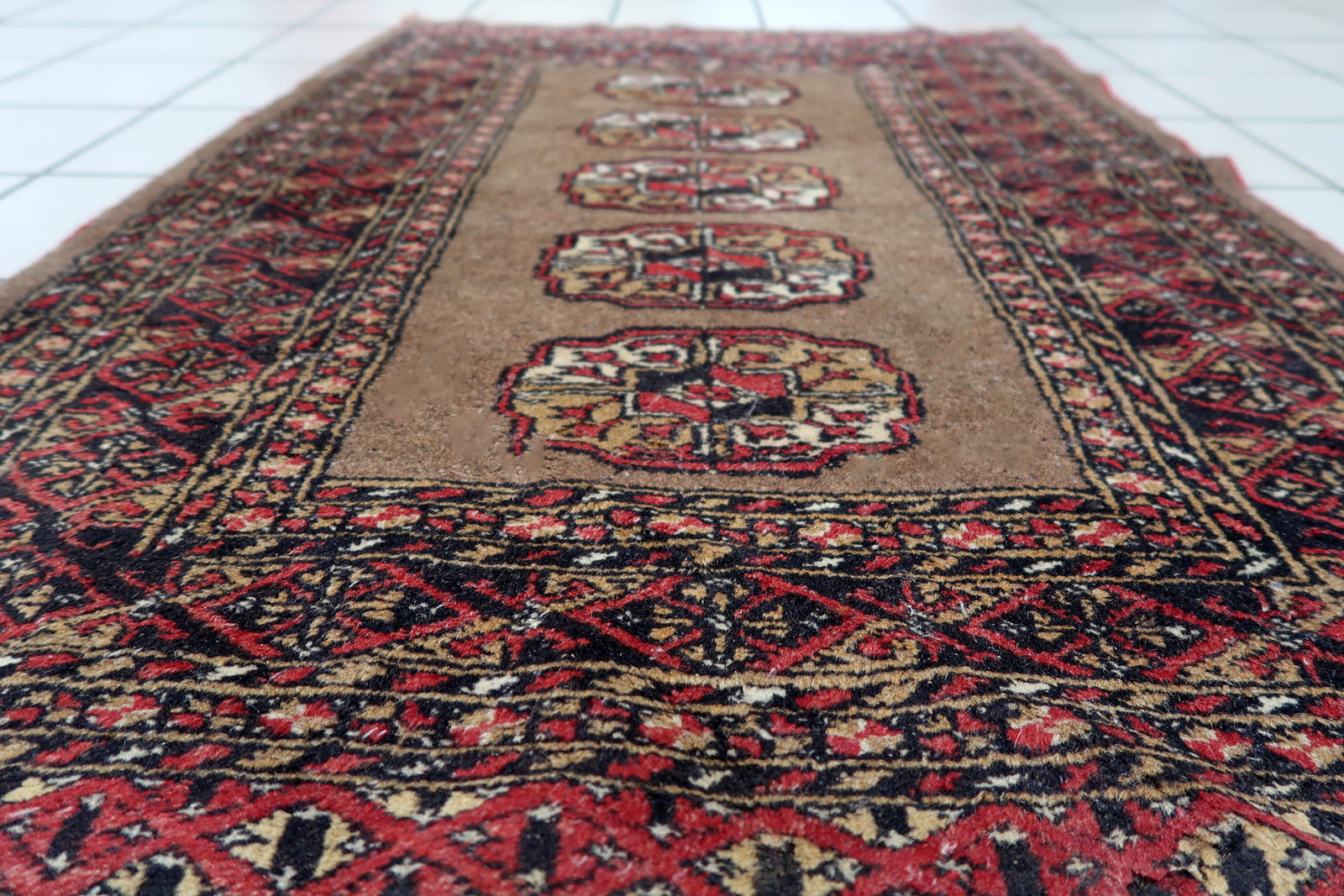 Small antique rug from Uzbekistan's Bukhara region with balanced symmetry and intact pile.

