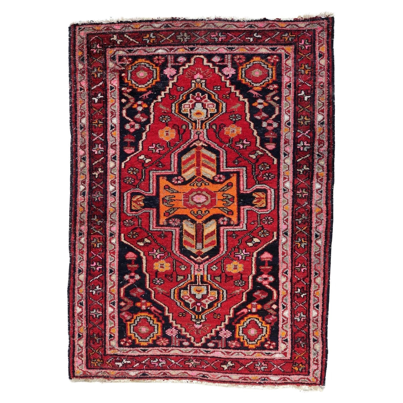 Antique Persian Hamadan rug from the 1920s featuring a dramatic central medallion with vibrant orange chevron patterns.

