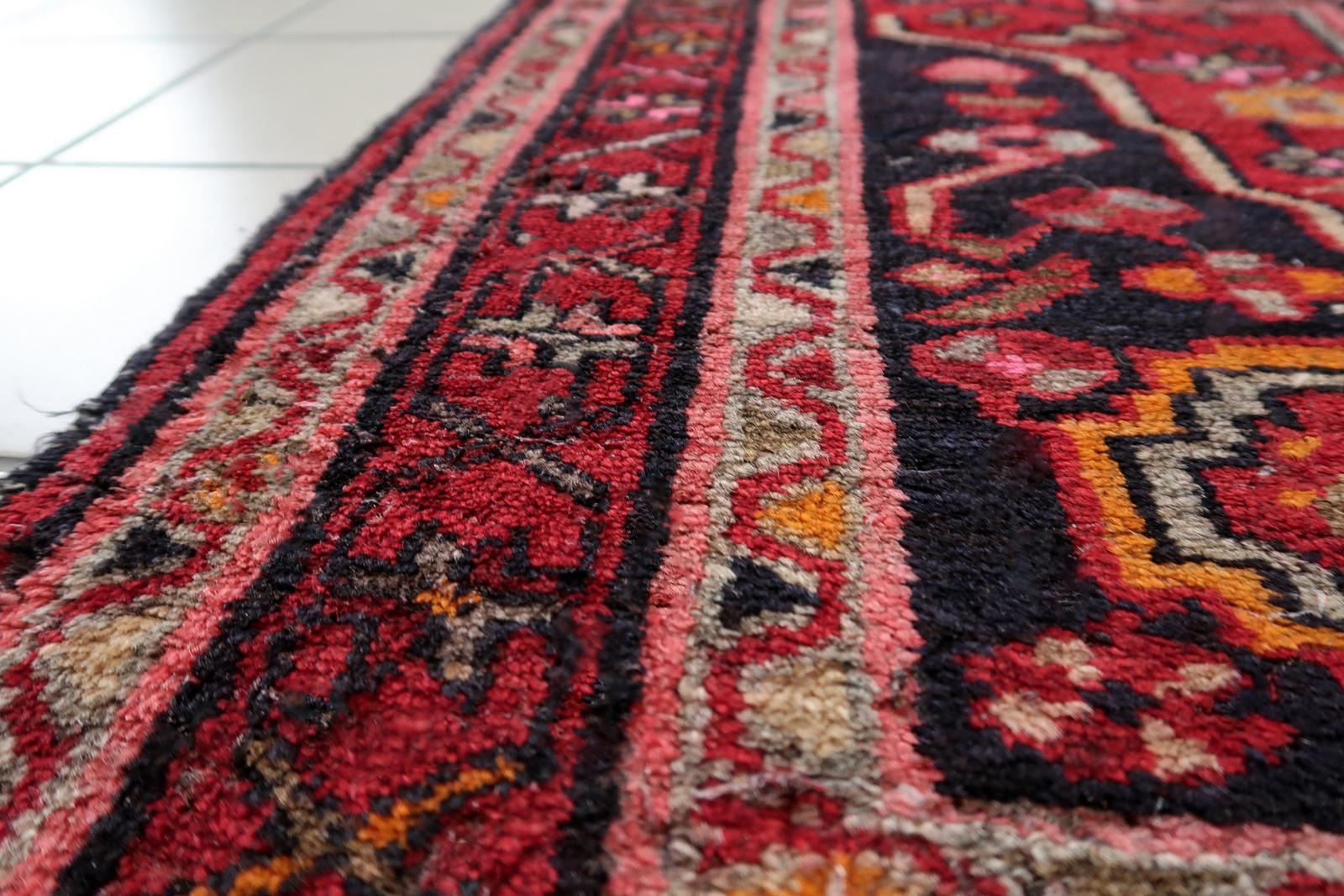 1920s Hamadan rug with deep navy blue accents and black outlines creating dramatic contrast.


