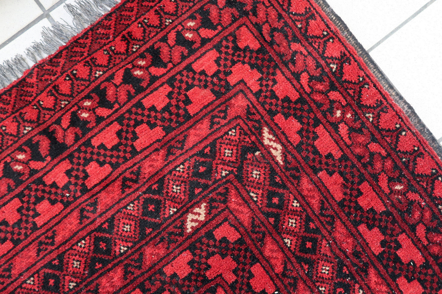 A 1920s Afghan Turkmen rug adding warmth and historical significance to a modern interior space.

