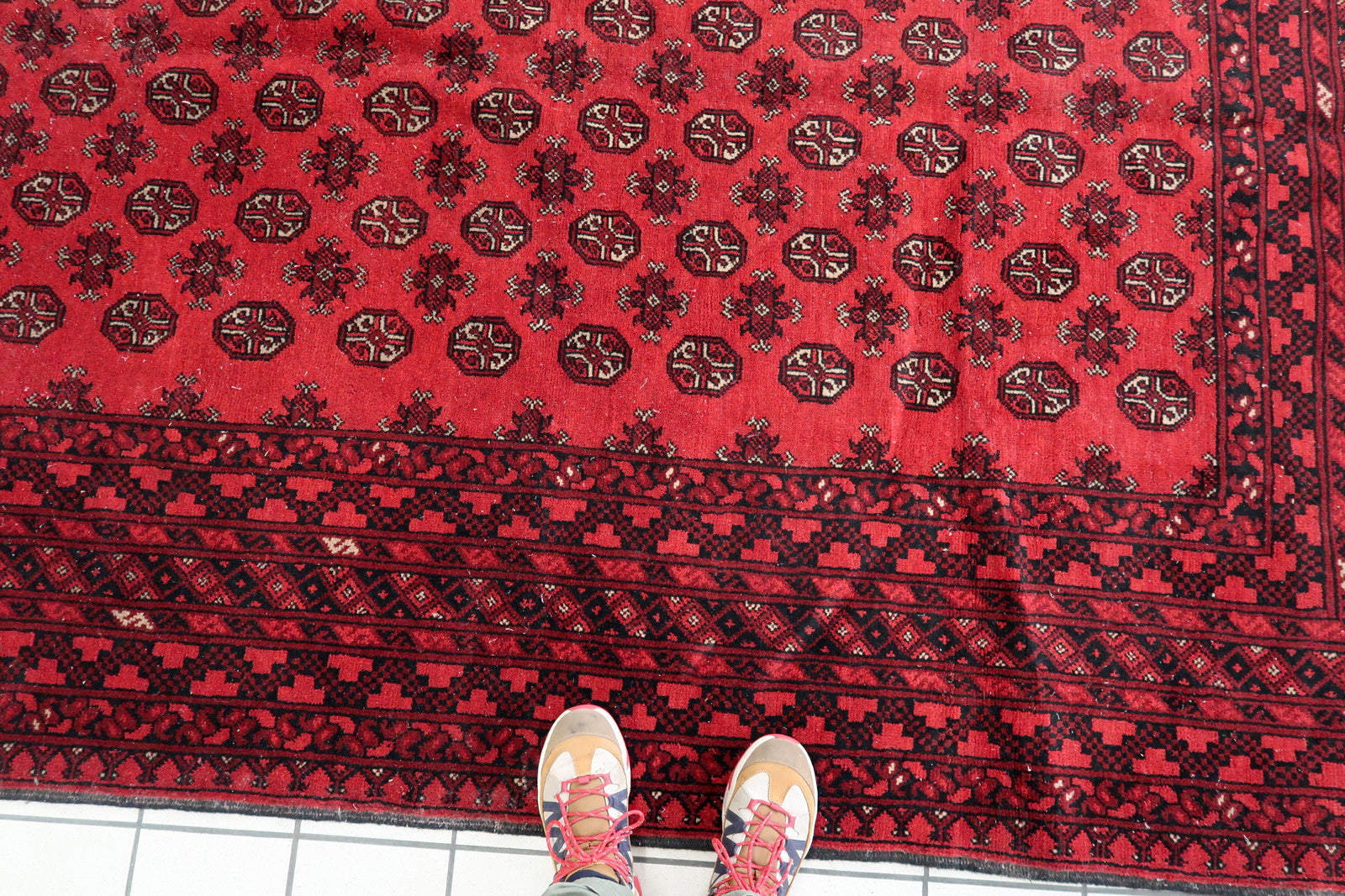 Antique tribal carpet with symmetrical pattern, ideal for collectors of Central Asian textiles and vintage home decor.


