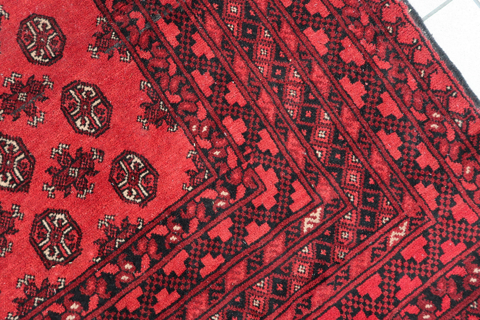 Well-preserved antique wool rug from Afghanistan, suitable for both formal and casual spaces with its versatile geometric design.

