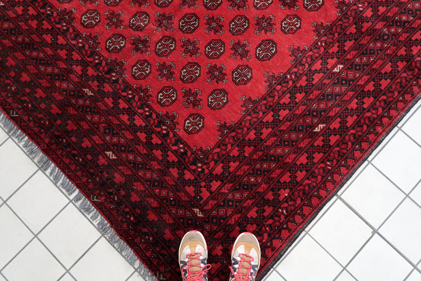 1920s vintage carpet with repeating gul medallions in coral-red and burgundy.

