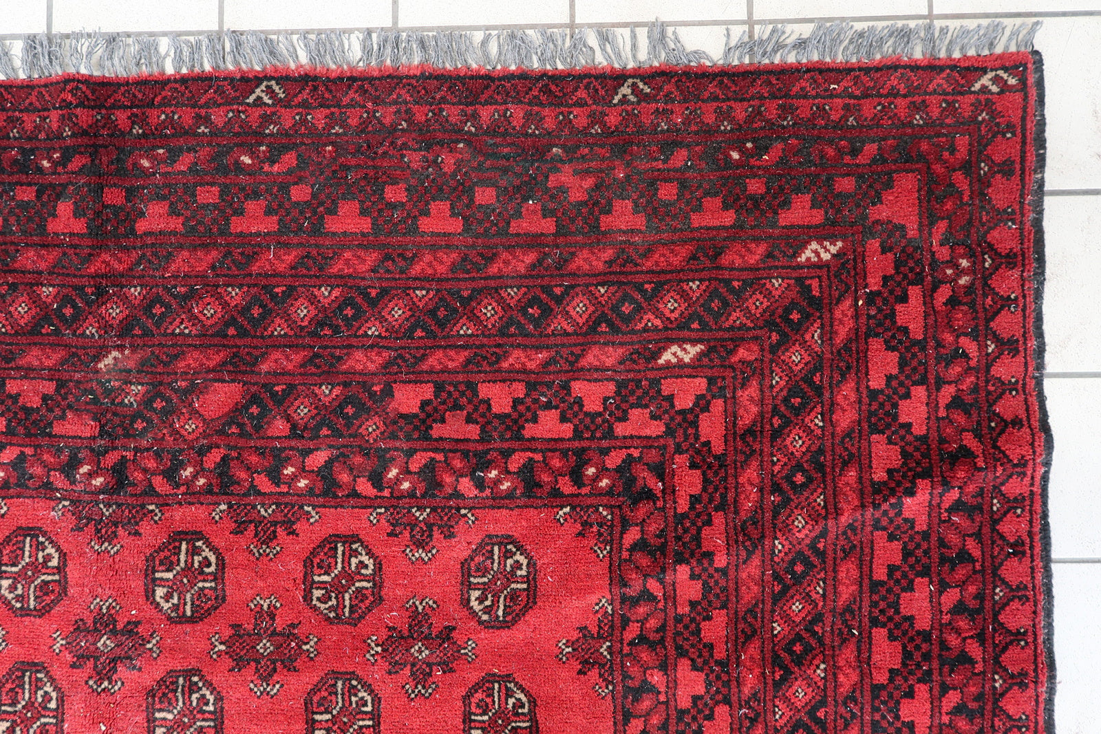 Large vintage Turkmen tribal carpet from Afghanistan, circa 1920. Classic Ersari design with deep burgundy medallions and geometric borders.

