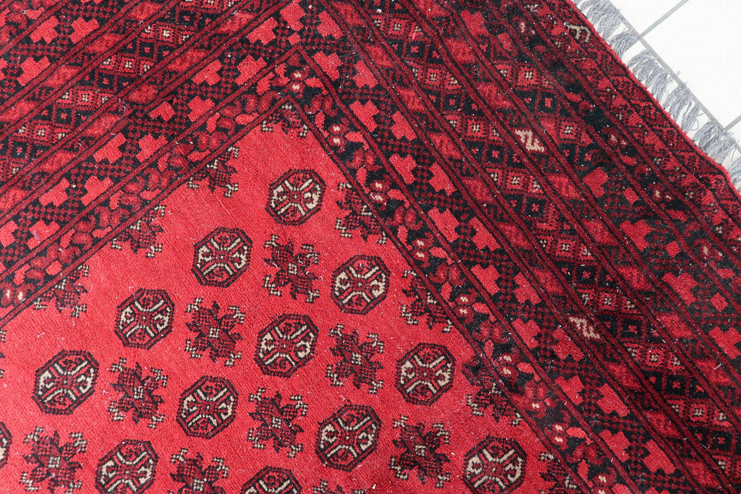 Handmade antique rug in generous room size (81.9" x 113.4") with well-preserved pile and natural dyes in coral-red, burgundy, and black.

