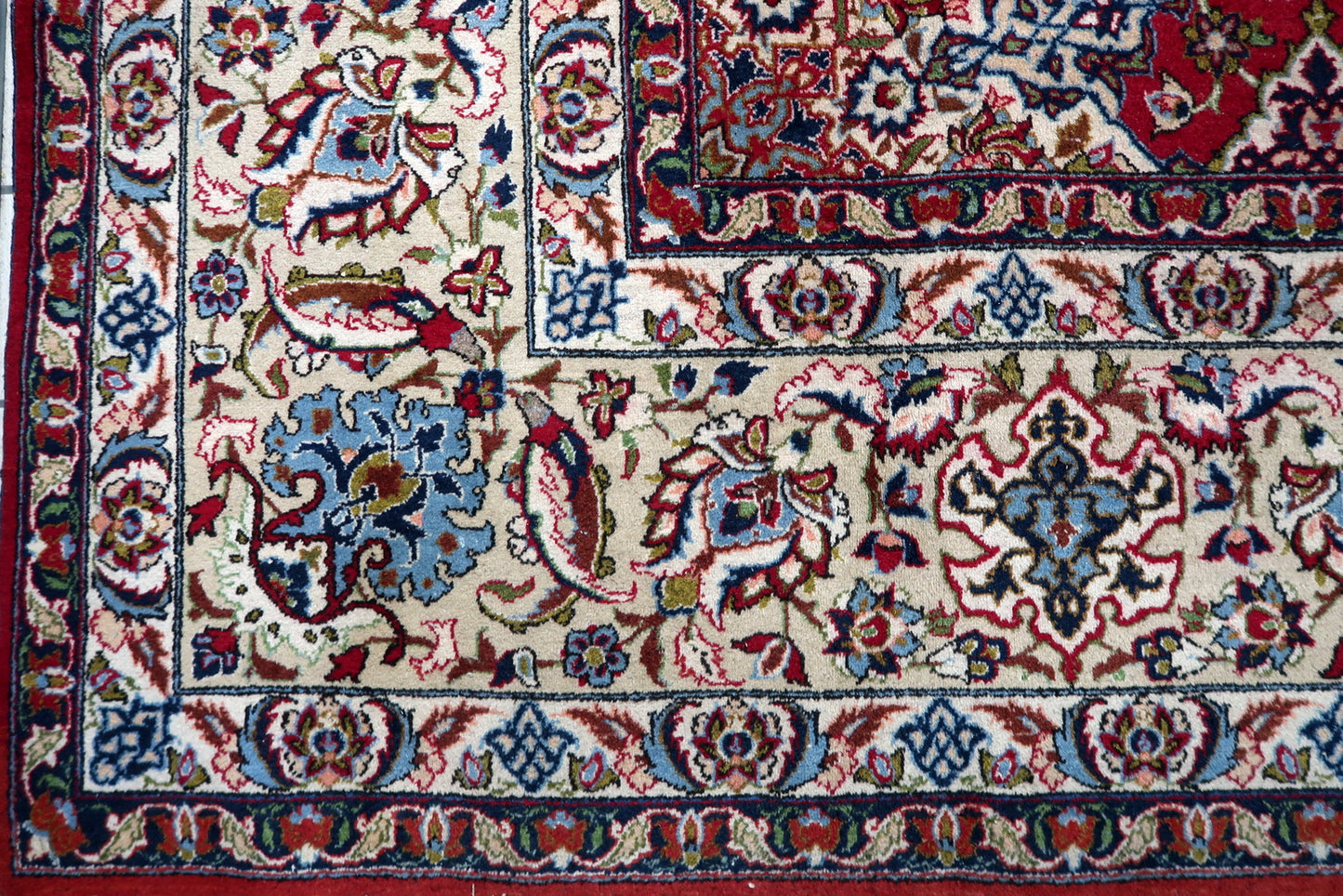 Early 20th century Persian Tabriz carpet featuring an all-over floral design on a rich crimson red field with a subtle central medallion.

