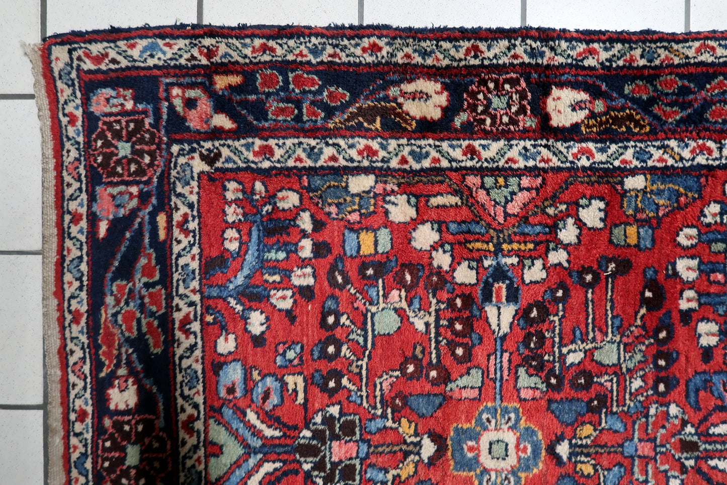 Long Persian village runner circa 1920, with a bold tribal aesthetic and triple medallion design on a deep madder-red field.

