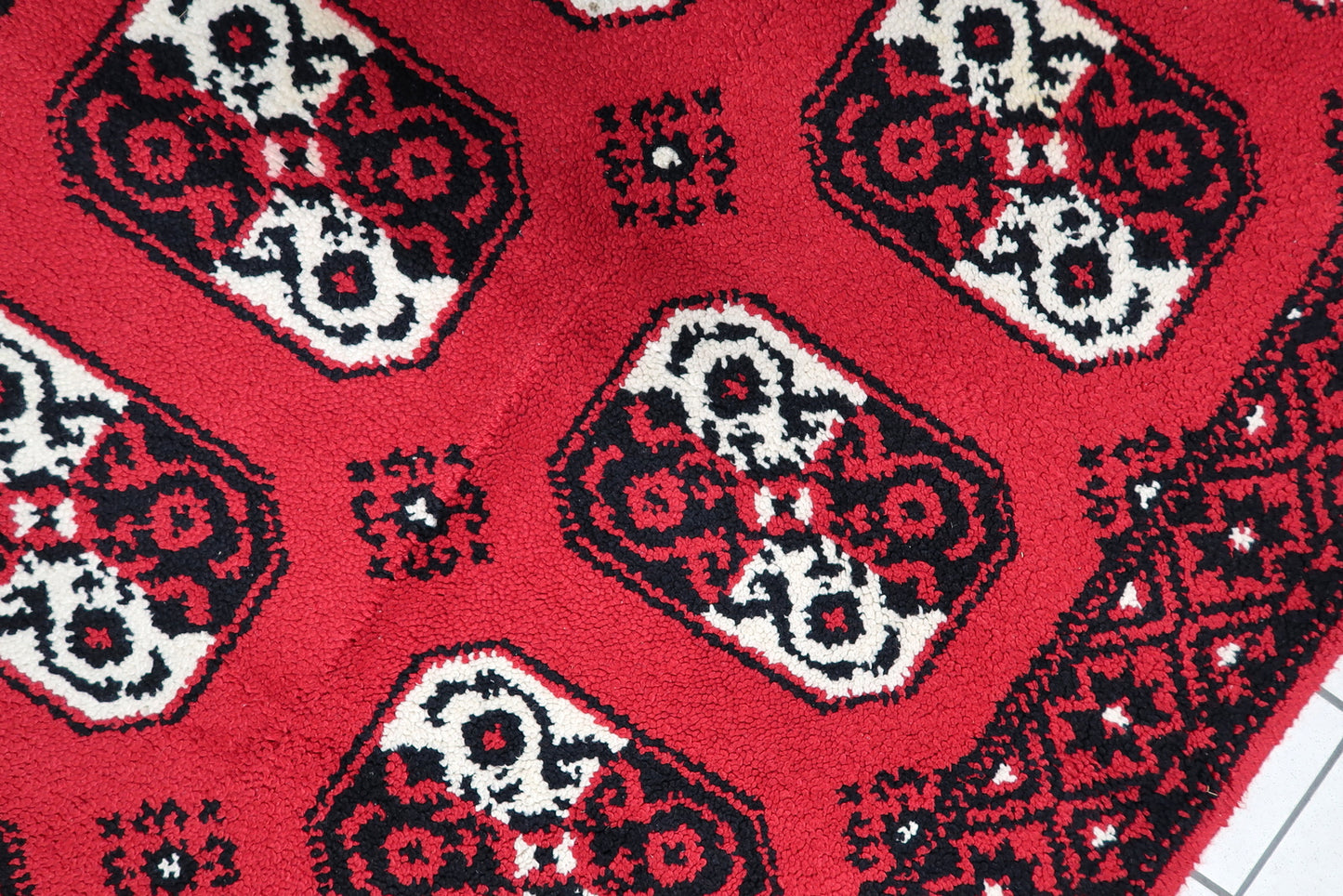 Mid-century modern statement rug in scarlet red, jet black, and cream, framed by a sophisticated geometric border. Dimensions: 144 cm x 230 cm.

