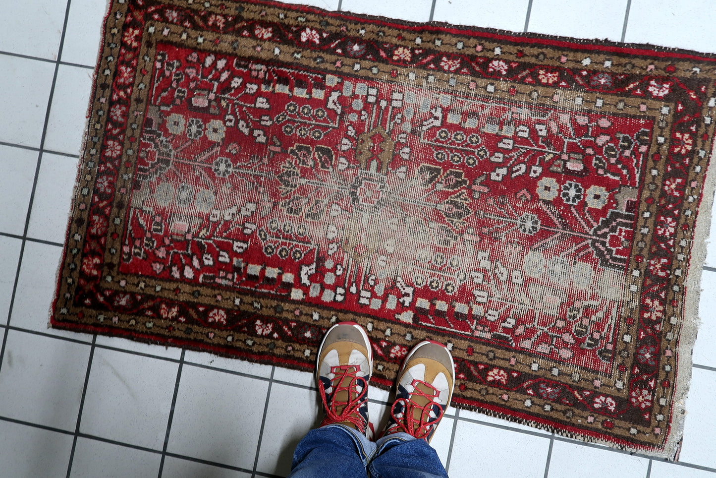 Antique distressed Persian Hamadan rug serving as a decorative accent in a hallway or entryway, adding instant character.

