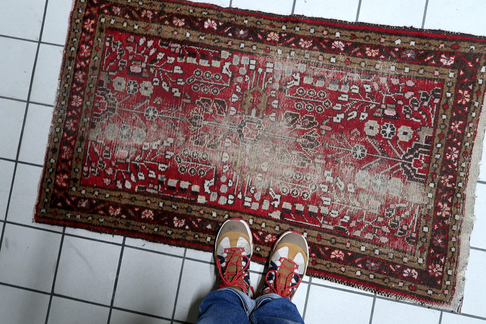 Antique distressed Persian Hamadan rug serving as a decorative accent in a hallway or entryway, adding instant character.

