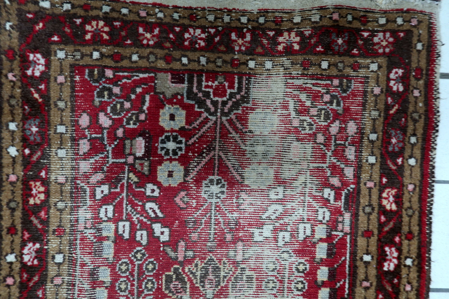 Small antique Persian rug (77 cm x 133 cm) with a powerful sense of history and a triple-border design in earthy browns, creams, and reds.

