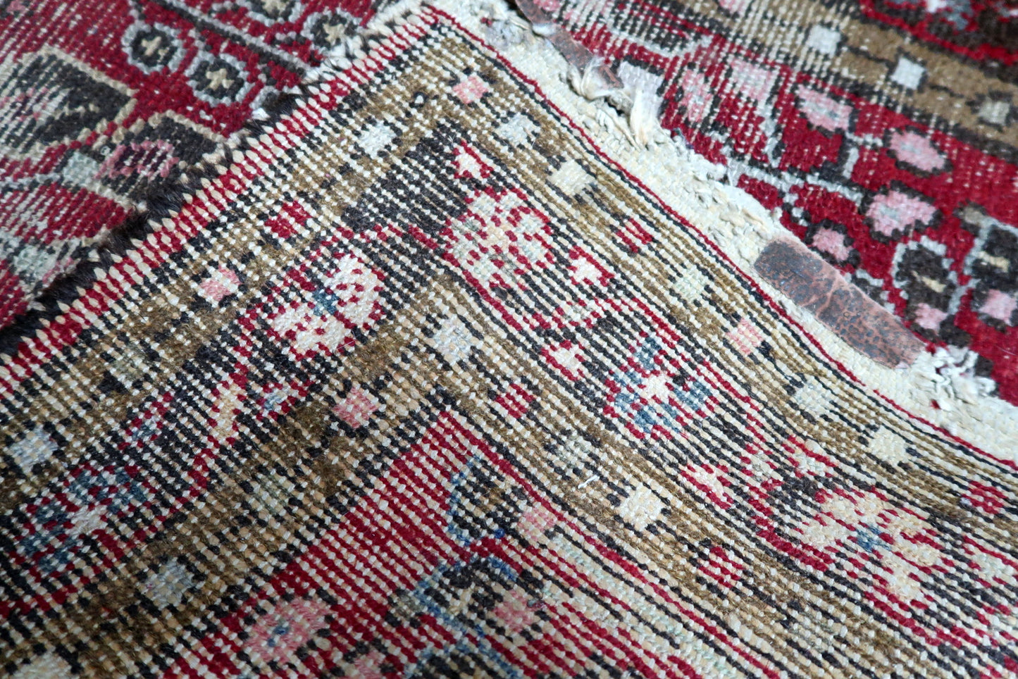 Texture close-up of century-old wool softened into a beautiful patina, offering a tactile connection to early 20th-century Persian artistry.

