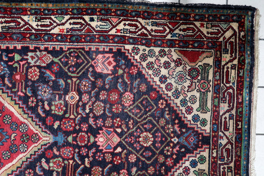 Early 20th century Persian village rug with a vibrant red and sky-blue central medallion, surrounded by stylized floral and geometric motifs. 3'8" x 6'7".

