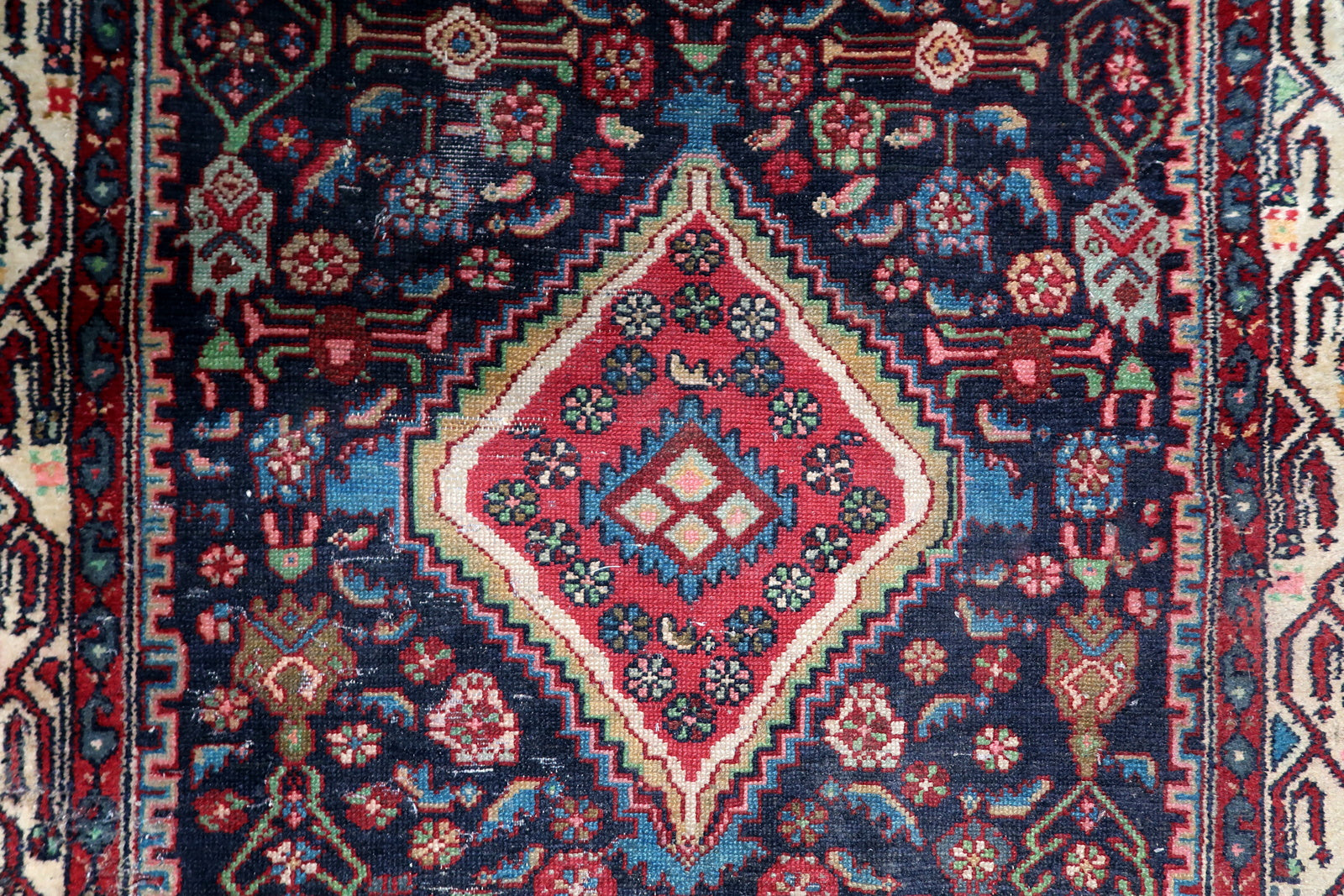 Elongated antique Persian rug (112 cm x 200 cm) with a multi-layered border and authentic century-old patina.

