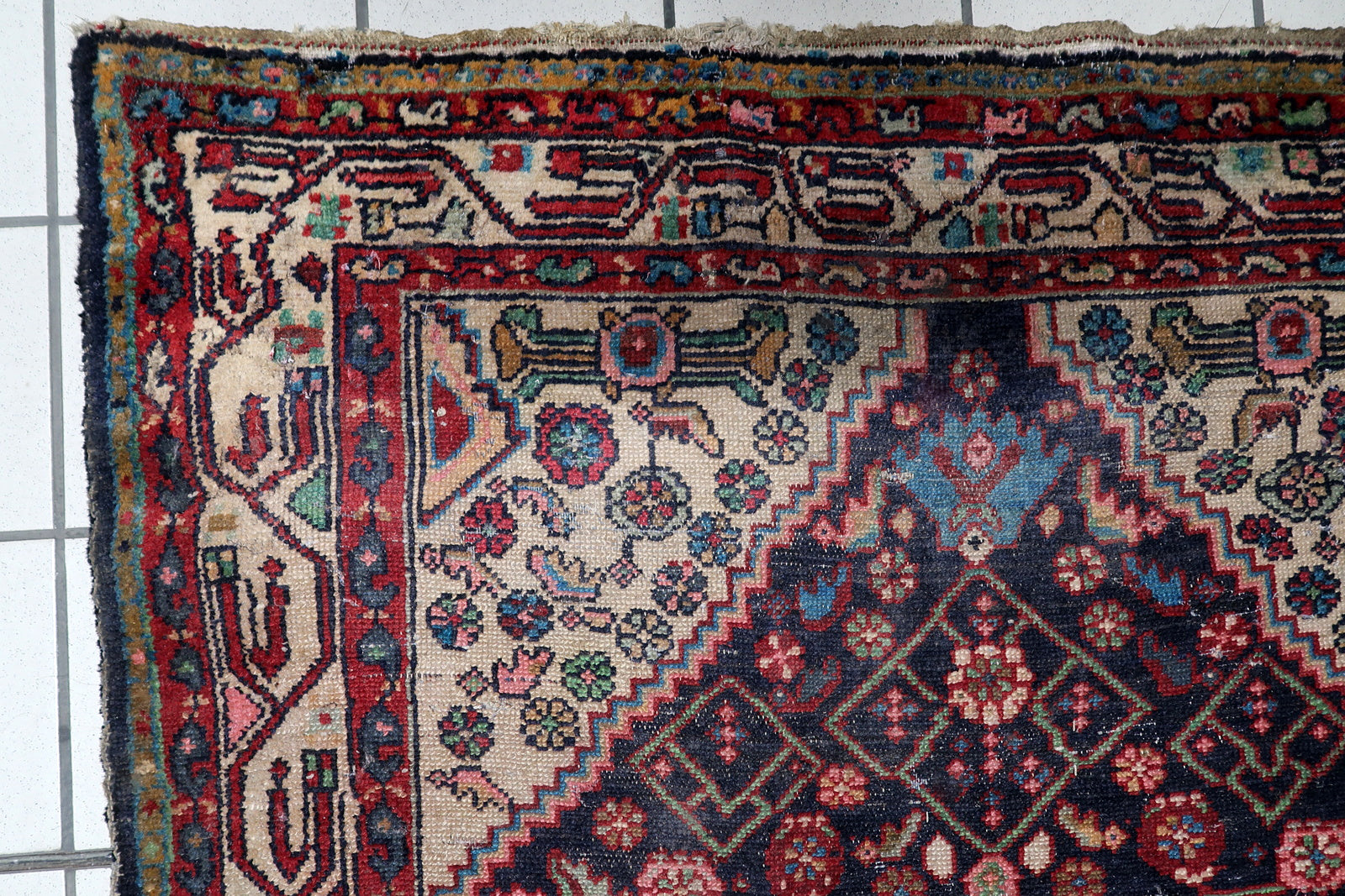 The multi-layered border of a Hamadan village rug, providing a structured, classical finish to the energetic tribal composition.

