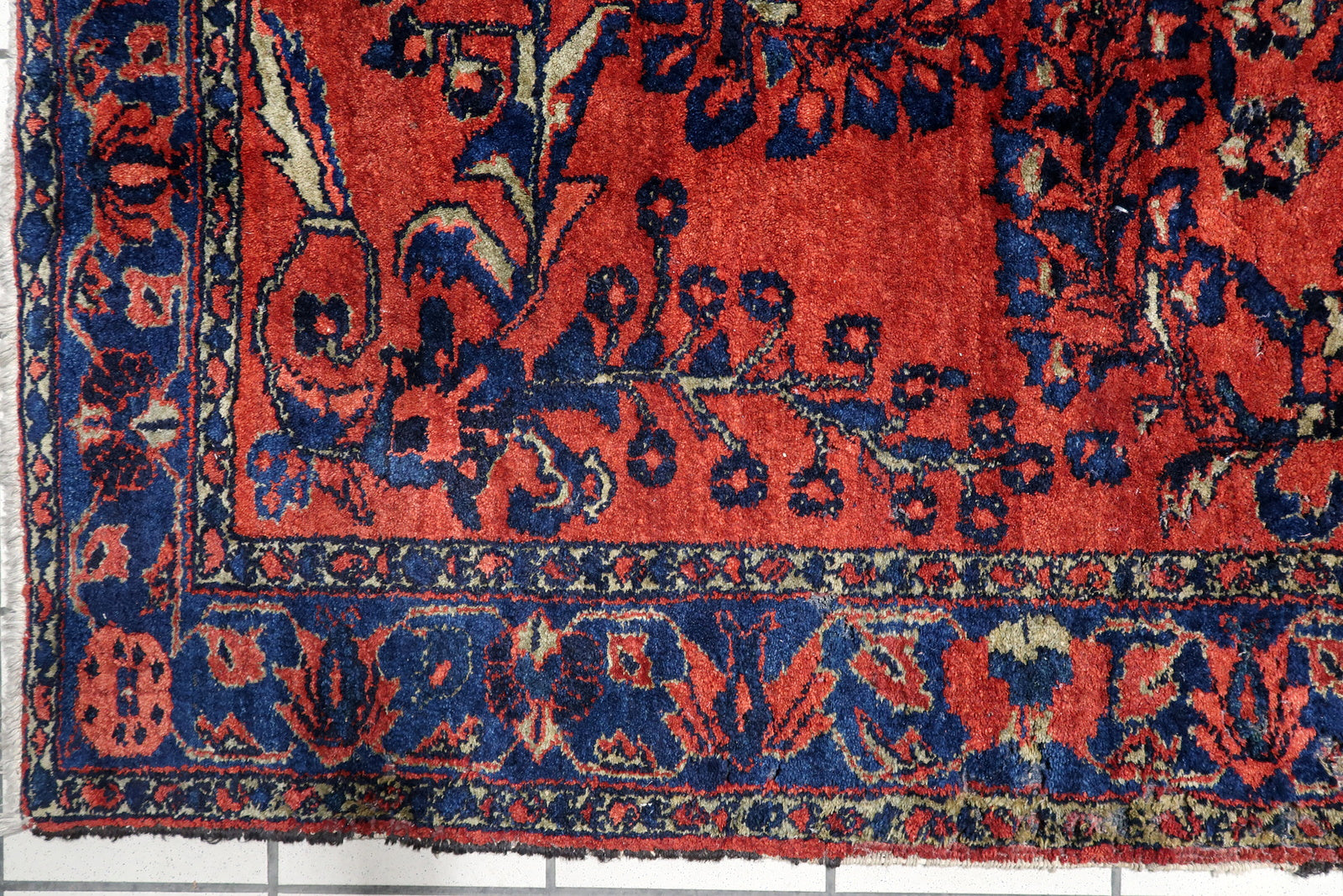 Early 20th century Persian village carpet with a rich madder-red field and symmetrical arrangement of blossoming branches in navy, teal, and gold. 5'8" x 6'7".

