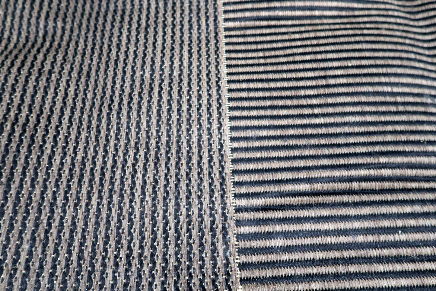 Detail of varying linear textures on a vintage modern rug, from tight ripples to broader horizontal ribs creating subtle plays of light and shadow.

