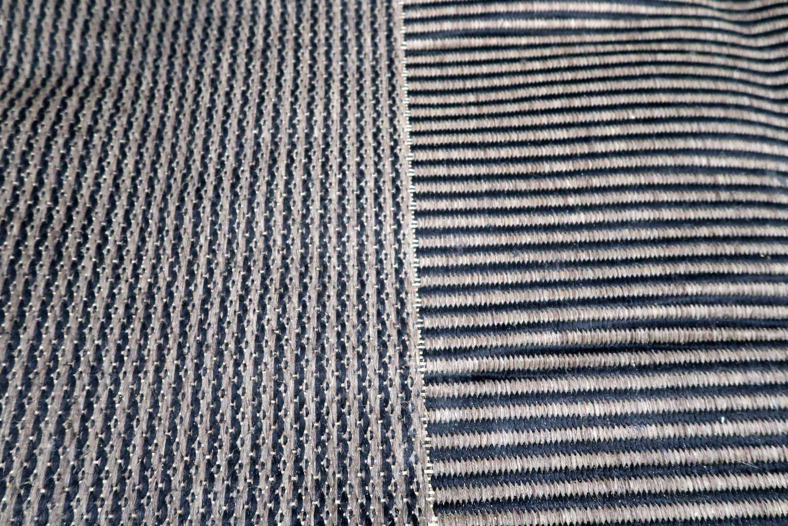Detail of varying linear textures on a vintage modern rug, from tight ripples to broader horizontal ribs creating subtle plays of light and shadow.

