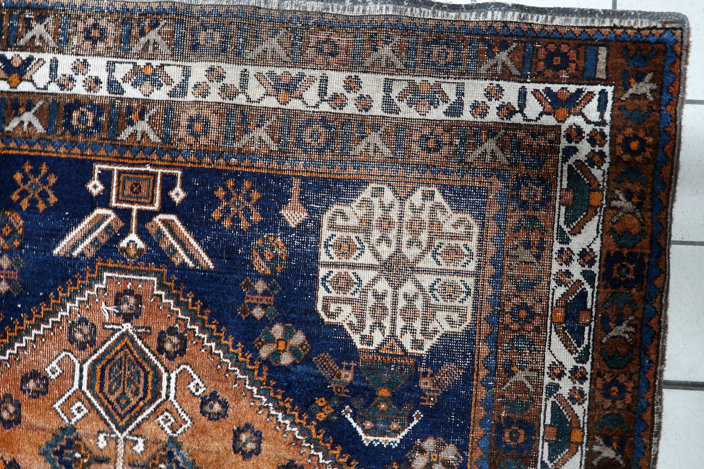 Early 20th century South Persian nomadic rug with ancient tribal symbols, including stylized "S" motifs, stars, and geometric floral heads. 5'1" x 6'9".

