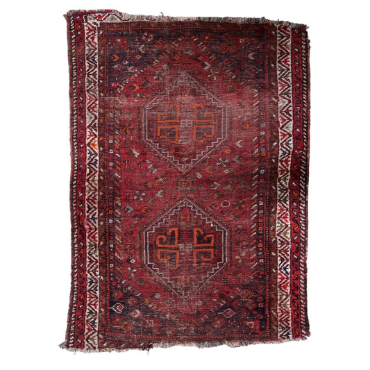Antique Persian Shiraz rug from the turn of the 20th century, hand-knotted wool, featuring two primary diamond medallions on a deep oxblood-red field. 93 x 126 cm.

