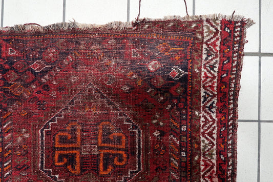 Early 1900s South Persian nomadic rug with archaic hooked "S" motifs and geometric tribal symbols in terracotta, midnight blue, and cream. 3'1" x 4'2".

