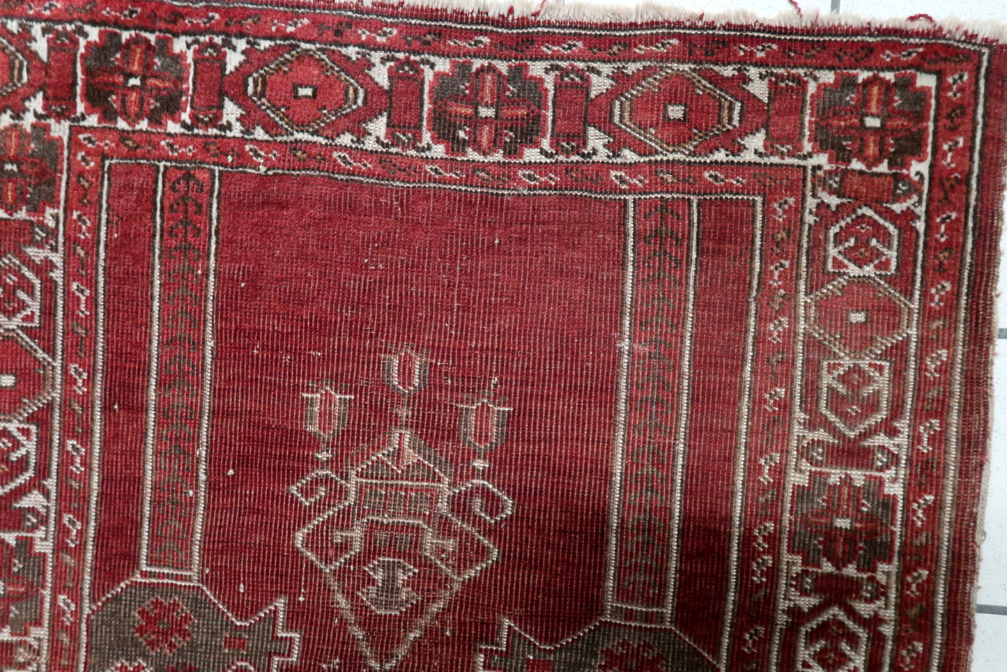 Handmade antique Konya prayer rug circa 1920s, showcasing a distressed character with very low pile revealing the structural integrity of the weaving.


