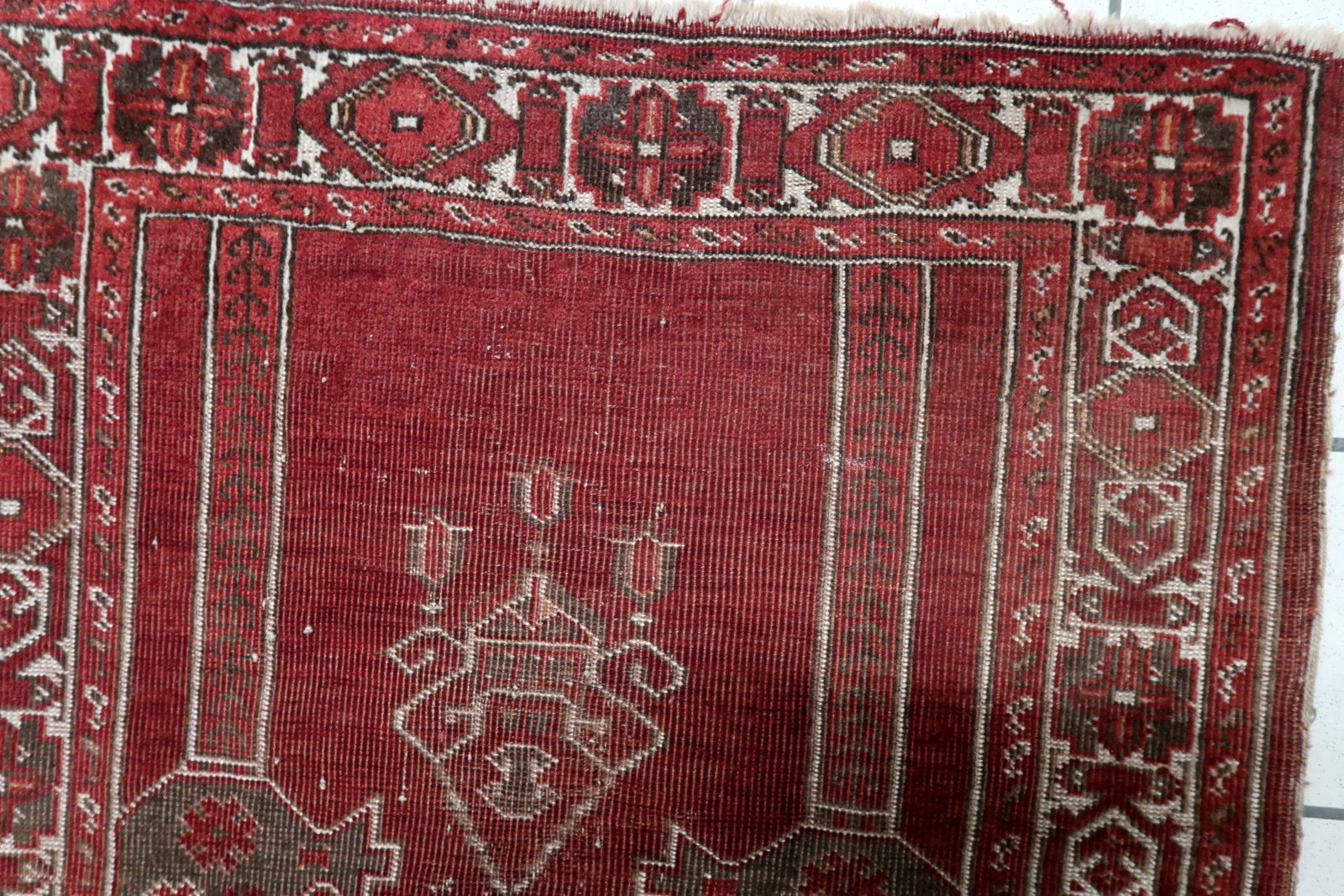 Handmade antique Konya prayer rug circa 1920s, showcasing a distressed character with very low pile revealing the structural integrity of the weaving.

