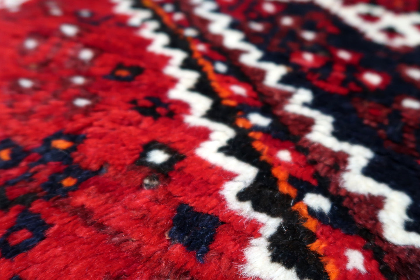 Antique wool rug in good condition featuring bold geometric patterns and traditional nomadic ornaments.
