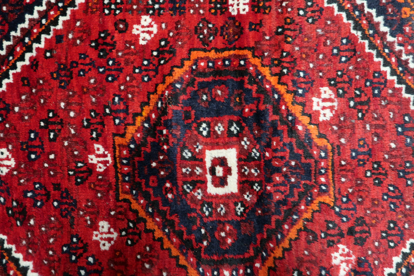 Aged natural wool pile of a 1920s Shiraz rug displaying beautiful abrash color variations and soft patina.

