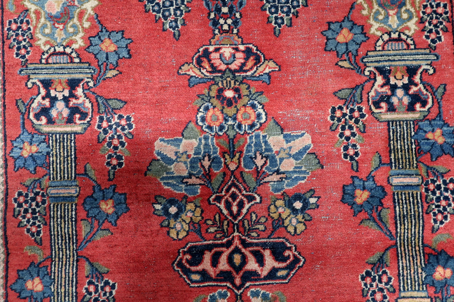 1920s handmade Persian rug with floral vase medallion and authentic areas of low pile from age.

