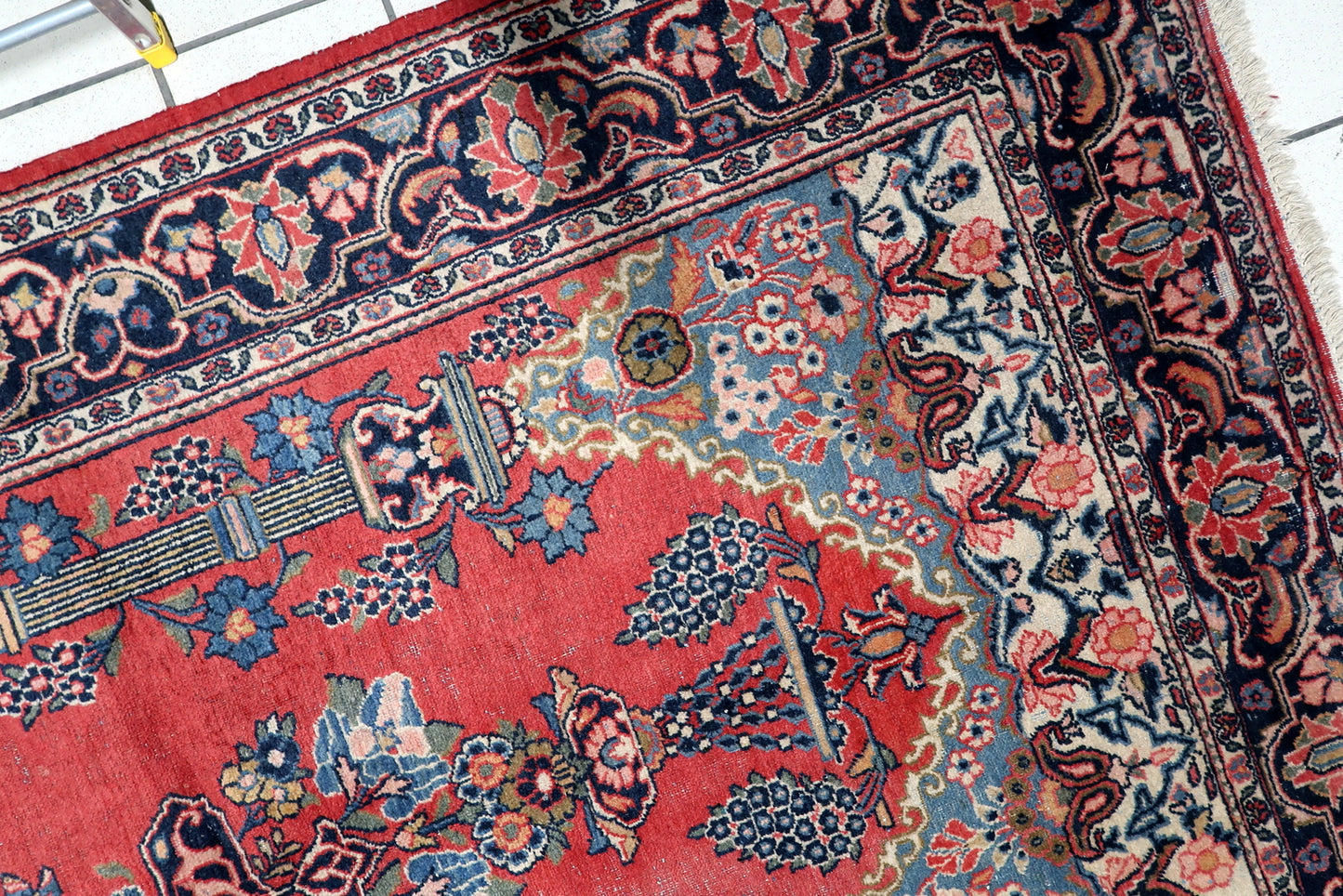 Full view of an antique Persian prayer rug showing elegant supporting columns and intricate floral details against a red background.

