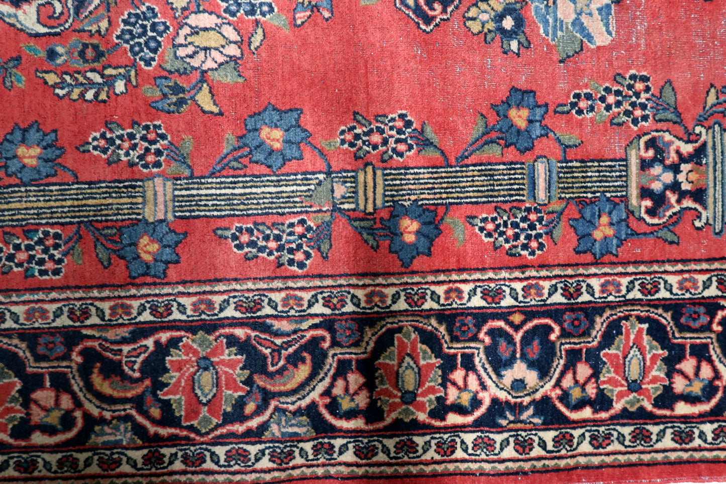 View of the upper section of an antique Persian prayer niche showing the refined Mihrab arch and column capitals.


