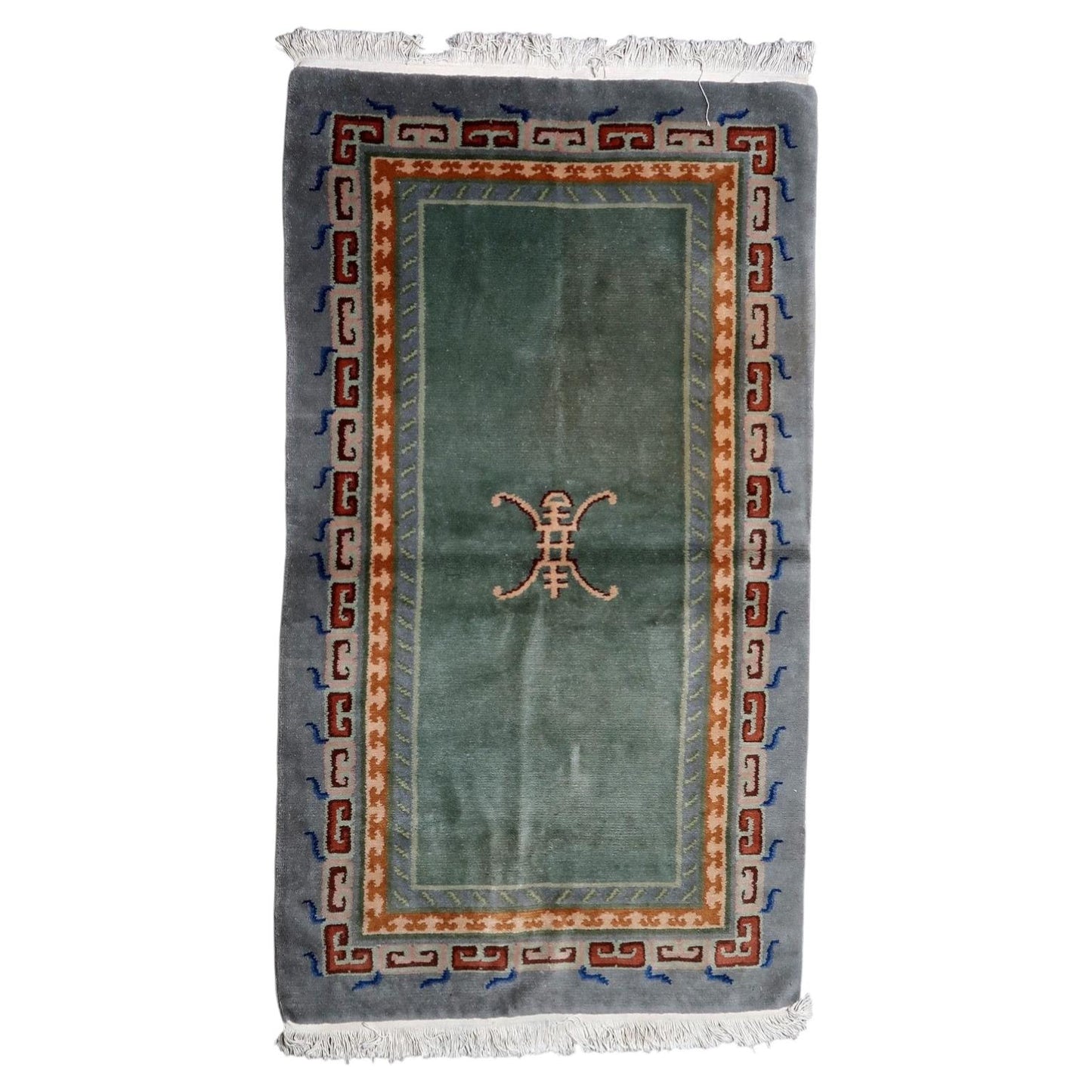 Vintage Tibetan Art Deco rug from the 1960s with moss-green field and abstract endless knot motif, handmade in Nepal, 3.7 x 6.4 feet