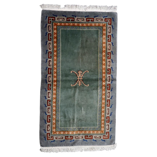 Vintage Tibetan Art Deco rug from the 1960s with moss-green field and abstract endless knot motif, handmade in Nepal, 3.7 x 6.4 feet