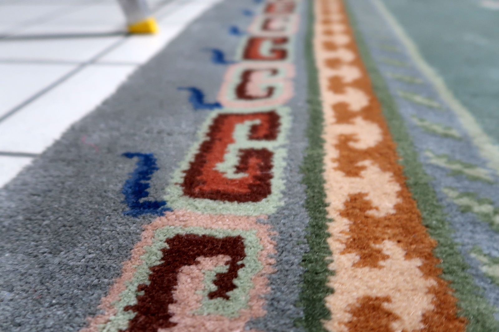 Hand-spun wool Tibetan rug in excellent vintage condition featuring abstract symbol of longevity and harmony
