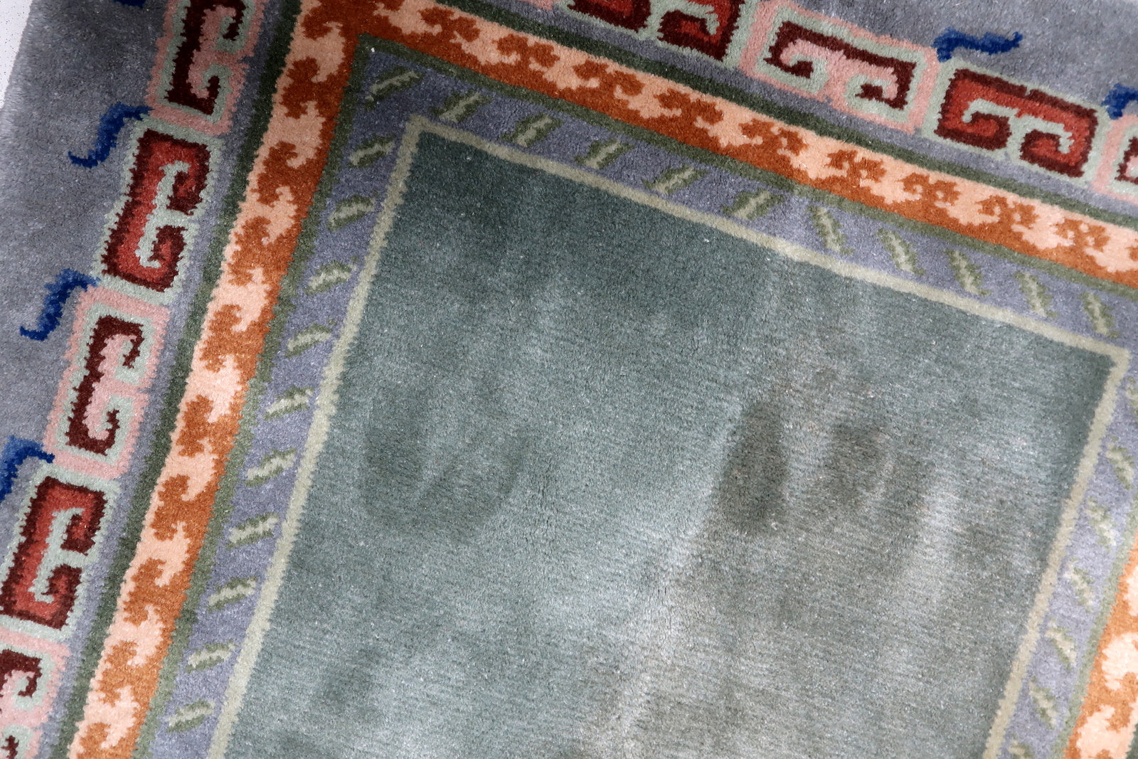 Moss green, slate grey, terracotta and navy blue vintage Tibetan rug with minimalist central field and bold architectural borders