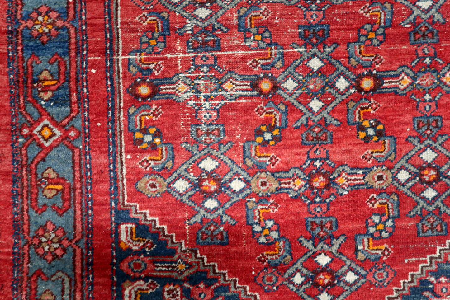 Detailed view of distressed low pile condition showing visible foundation and authentic century-old wear pattern