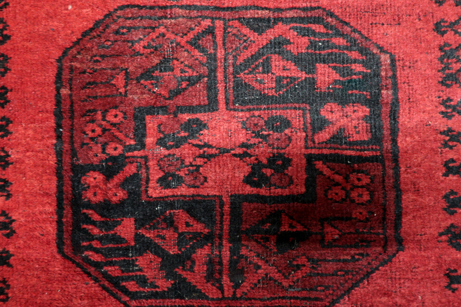 Hand-knotted wool rug in original good condition featuring authentic low areas consistent with century of use