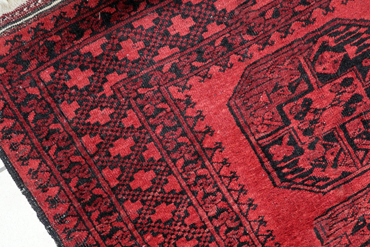 Full view of an antique Central Asian tribal rug featuring vertical row of traditional Turkmen guls and star borders