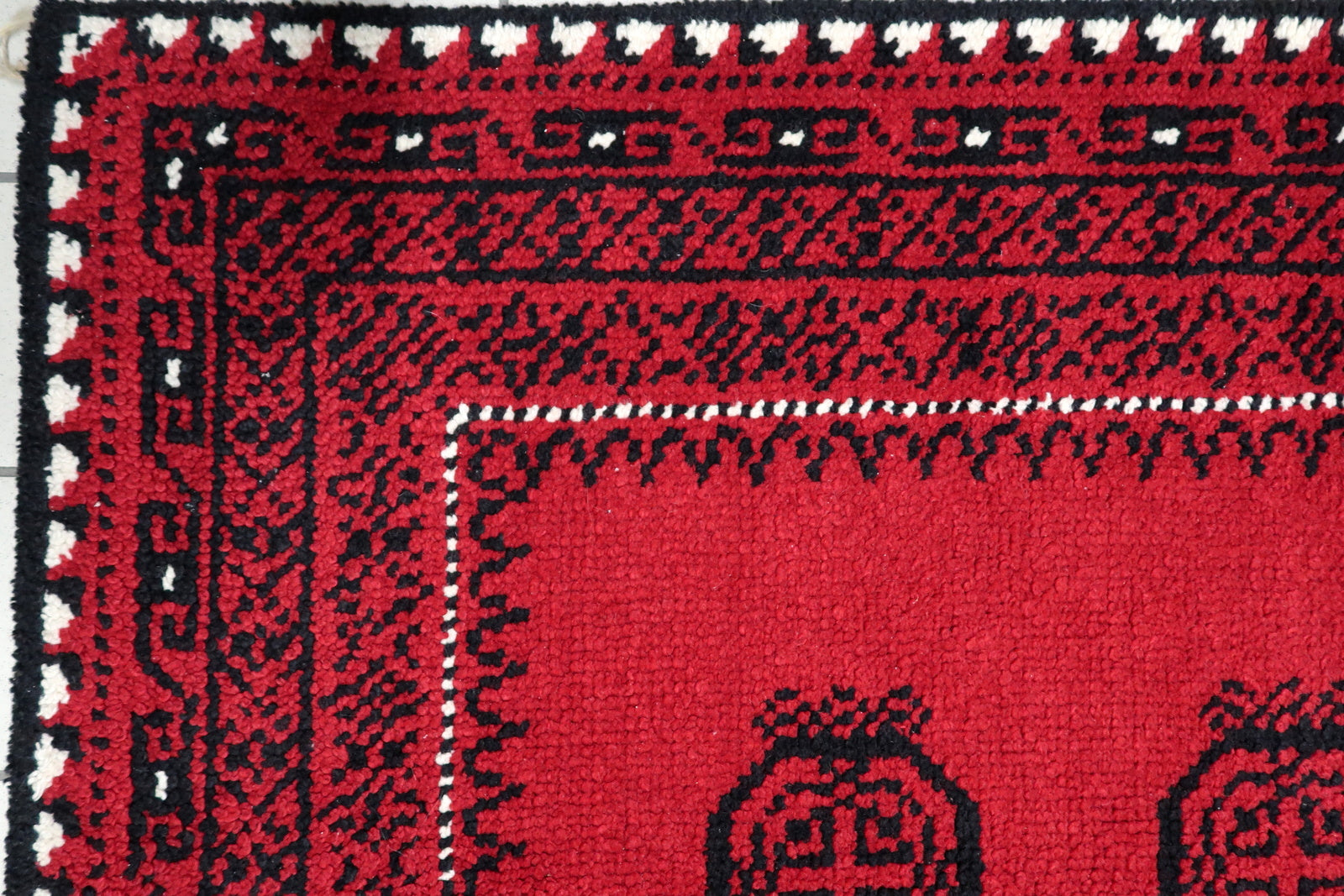 Close-up of intricate onyx black rosette medallion with detailed floral motifs on a vintage French wool carpet