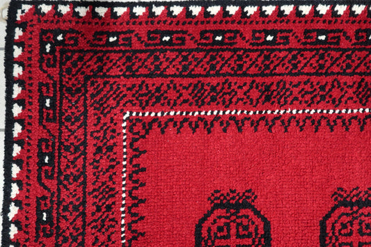 Close-up of intricate onyx black rosette medallion with detailed floral motifs on a vintage French wool carpet