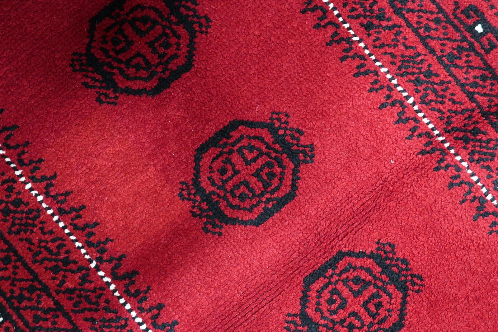 View of delicate pearl inner guard border framing the vibrant crimson field of a French neoclassical floor covering