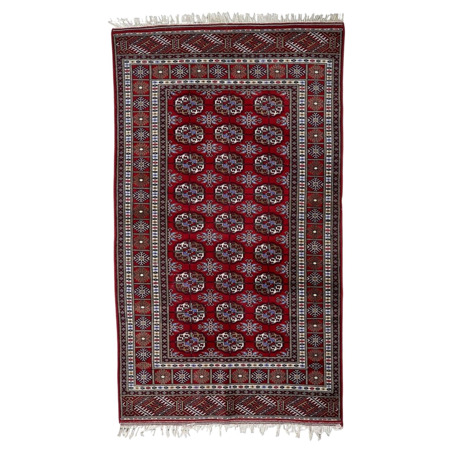 Vintage Uzbek Bukhara wool rug from the 1960s with crimson red field and repetitive octagonal gul motifs, 4 x 7 feet